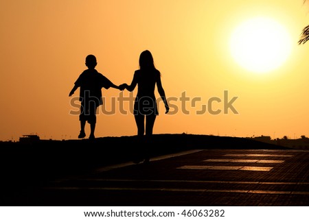 silhouette of a young woman with the child to walk