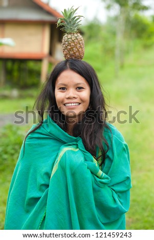 South-east asian woman with pineapple on her head