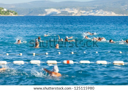 OMIS, CROATIA - AUGUST 28, 2012: Boys warming up before the water polo training.  on August 28, 2012 in Omis, Croatia. Water polo is rampant sport among youth in Dalmatia.