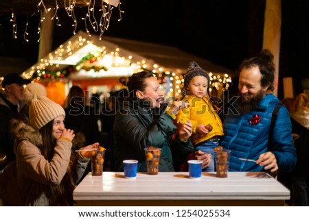Family enjoying traditional food at Christmas market in Zagreb, Croatia.