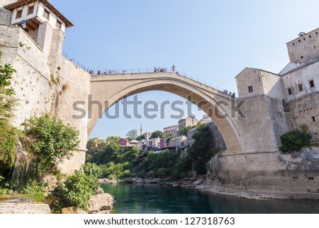 MOSTAR, BOSNIA - AUGUST 10: Man ready to jump from old bridge on August 10, 2012 in Mostar, Bosnia. It is a tradition for men to dive off the 21m bridge to impress visitors and earn some extra money.