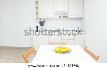 Modern and bright kitchen area in house interior with lemons on table