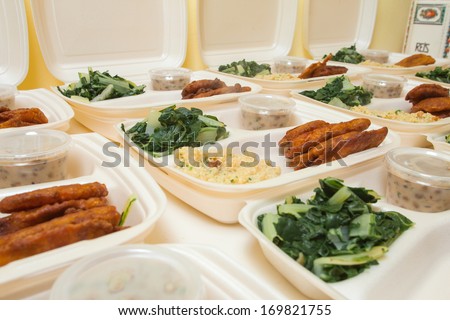 White styrofoam lunch boxes containing tofu, swiss chard, and rice