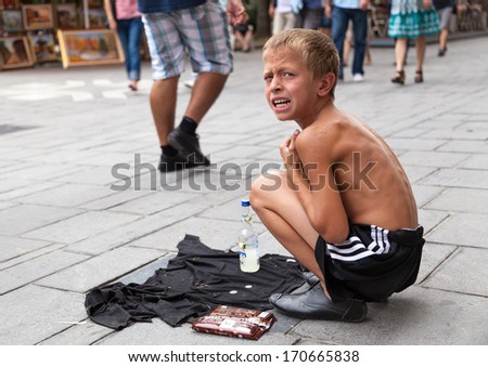 SARAJEVO, BOSNIA AND HERZEGOVINA - AUG 11: Sevdalija Osmanovic, 10 years old, sings on street to bypassers on August 11, 2012 in Sarajevo, B&H. He sings in order to provide money for his family.