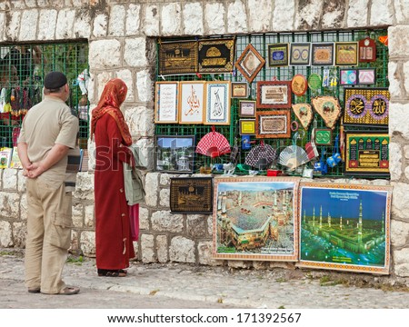 SARAJEVO, BOSNIA AND HERZEGOVINA - AUGUST 13, 2012: Muslim couple in front of the street stand with islamic souvenirs.