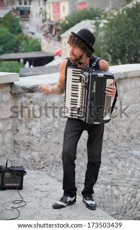 MOSTAR, BOSNIA AND HERZEGOVINA - AUGUST 9, 2012: Street musician plays accordion. The streets of Mostar are the stage of the Arts Festival.
