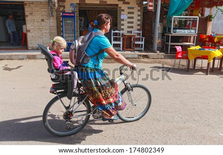DAHAB, EGYPT - JANUARY 28, 2011: Local woman drives her daughter on a bicycle. The Girls Revolution is now launching a new campaign \