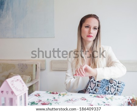 Attractive young woman in the restaurant looking at watch.