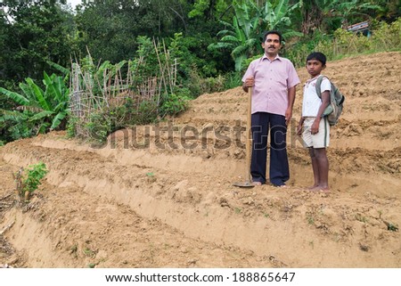 ELLA, SRI LANKA - MARCH 2, 2014: Local farmer and his son stand on tea plantation. Ella is famous for the tea plantations and stunning views across the countryside.