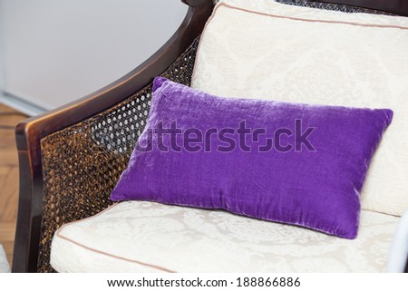 Purple pillow on wooden chair in house