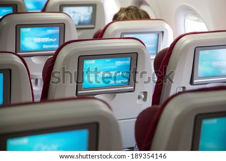 DOHA, QATAR - FEBRUARY 18, 2014: Economy class seats with entertainment system onboard. Qatar Airways Economy Class was named best in the world in the 2009 and 2010 Skytrax Awards.
