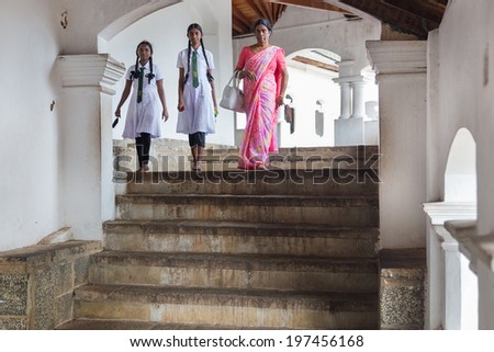DAMBULLA, SRI LANKA - FEBRUARY 27, 2014: Local women visiting Dambulla cave temple. It is the largest, best-preserved cave-temple complex in Sri Lanka listed as UNESCO World Heritage site.