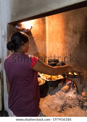 HIKKADUWA, SRI LANKA - FEBRUARY 23, 2014: Local woman preparing dinner. Locals prepare dinner in their own home for tourists to enjoy real traditional food.