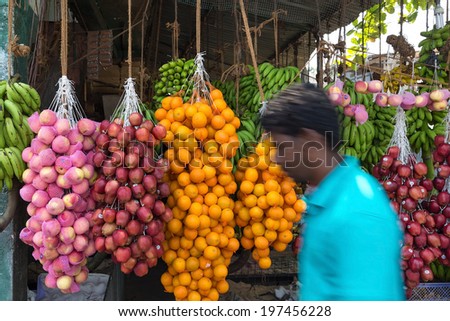 HIKKADUWA, SRI LANKA - FEBRUARY 22, 2014: Local man passing by street fruit stand. Most famous are stands  at Sunday market.