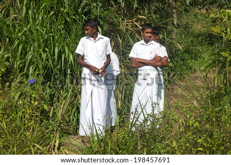 NUWARA ELIYA, SRI LANKA - MARCH 2, 2014: Young local boys on tea plantation. Tea production generates $700 million annually to the economy of Sri Lanka.