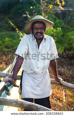 UNAWATUNA, SRI LANKA - MARCH 6, 2014: Local fisherman posing by his boat. Tourism and fishing are two main business in this town.