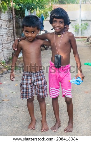 HIKKADUWA, SRI LANKA - MARCH 8, 2014: Local kids playing on the streets of Hikkaduwa village. These communities have tight knit bonds which show up in the streets.
