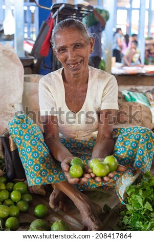 HIKKADUWA, SRI LANKA - MARCH 9, 2014: Local market vendor selling lime. The Sunday market is a fantastic way to see Hikkaduwa\'s local life come alive along with fresh produce and local delicacy.