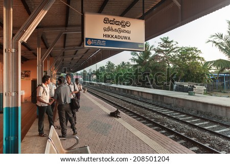 HIKKADUWA, SRI LANKA - FEBRUARY 22, 2014: Commuters wait for train at Hikkaduwa station. Trains are very cheap and poorly maintained but it\'s the best option to witness a bit of everyday local life.