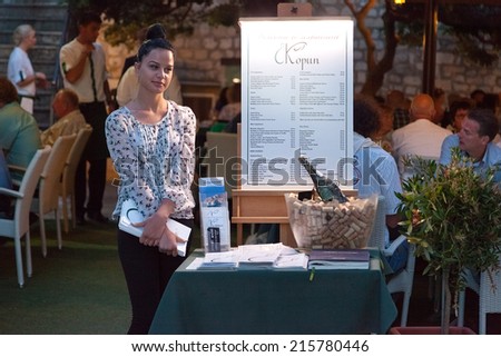 DUBROVNIK, CROATIA - MAY 28, 2014: Restaurant Kopun\'s hostess standing in front of the entrance. Dubrovnik has many restaurants which offer traditional Dalmatian cuisine and some great wine lists.