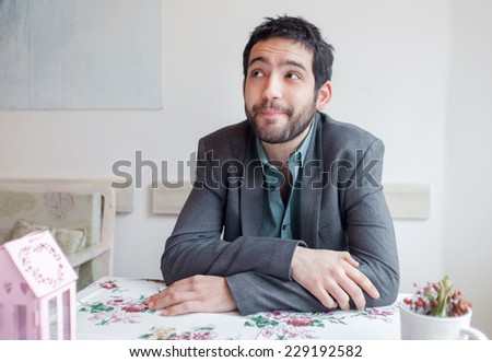 Young man wearing jacket sitting in restaurant.