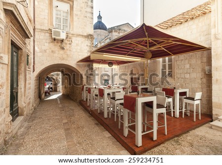 DUBROVNIK, CROATIA - MAY 26, 2014: Empty restaurant terrace in the street passage. Dubrovnik has many restaurants which offer traditional Dalmatian cuisine and some great wine lists.