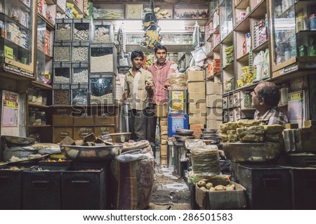 JODHPUR, INDIA - 10 FEBRUARY 2015: Three men in various merchandise store talk business. Post-processed with grain and texture.