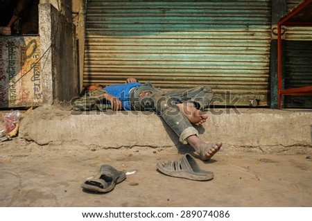 JODHPUR, INDIA - 10 FEBRUARY 2015: Drunk Indian man passed out on street.