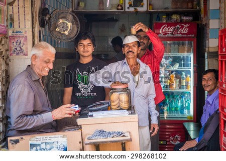MUMBAI, INDIA - 17 JANUARY 2015: Street scene with men in front of small shop in town.