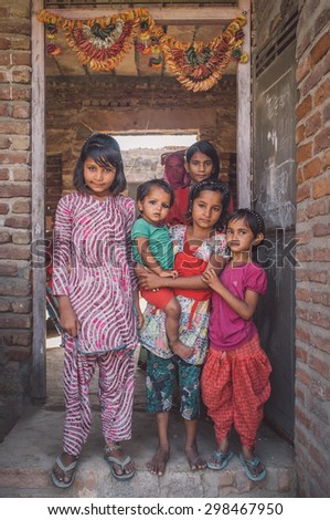 GODWAR REGION, INDIA - 15 FEBRUARY 2015: Six girls from same family stand in doorway under decorated door arch. Post-processed with grain, texture and colour effect.
