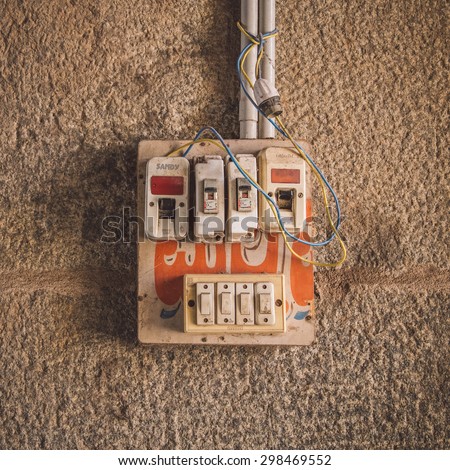 HAMPI, INDIA - 28 JANUARY 2015: Small safety fuse with switches on stone wall. Post-processed with grain, texture and colour effect.