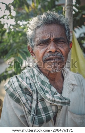 HAMPI, INDIA - 31 JANUARY 2015: Indian elderly man with checked scarf. Post-processed with grain, texture and colour effect.