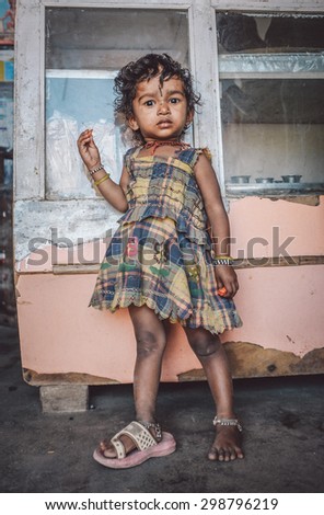 KAMALAPURAM, INDIA - 02 FABRUARY 2015: Indian child stands inside a shop on a market close to Hampi. Post-processed with grain, texture and colour effect.