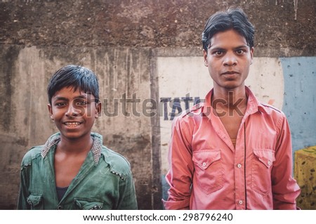 MUMBAI, INDIA - 12 JANUARY 2015: Young Indian men in Dharavi slum. Post-processed with grain, texture and colour effect.