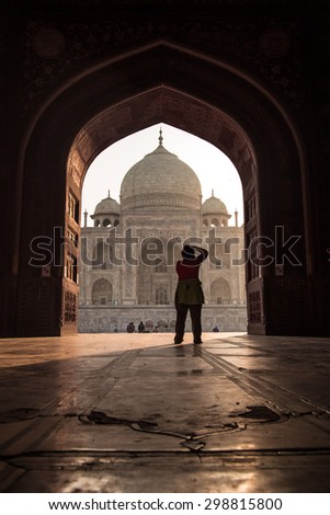 AGRA, INDIA - 28 FEBRUARY 2015: View of Taj Mahal from mosque. Woman photographing Taj. West side.