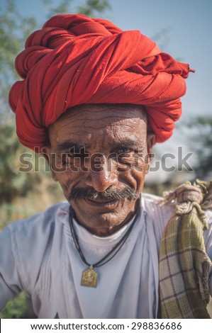 GODWAR REGION, INDIA - 14 FEBRUARY 2015: Elderly Rabari tribesman with red turban. Post-processed with grain, texture and colour effect.