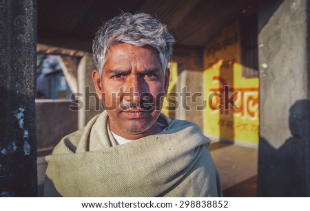 GODWAR REGION, INDIA - 14 FEBRUARY 2015: Adult Indian man with grey hair stands in street. Post-processed with grain, texture and colour effect.