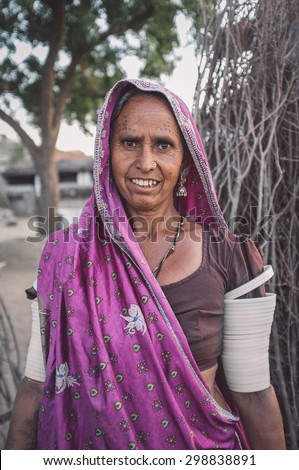 GODWAR REGION, INDIA - 12 FEBRUARY 2015: Tribeswoman decorated with traditional tattoos on face,  jewelry and upper arm bracelets. Post-processed with grain, texture and colour effect.