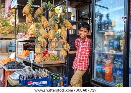HOSPET, INDIA - 04 FEBRUARY 2015: Indian boy waiting with pineapples in front of store.