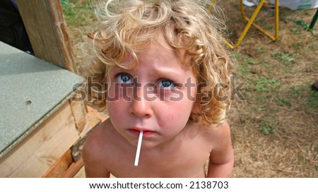 stock photo little girl sucking her lolly and looking up