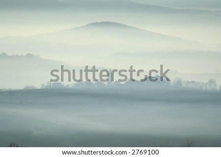 misty village with mountain in backgroud