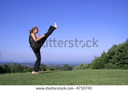 high kick - attractive young woman practicing self defense