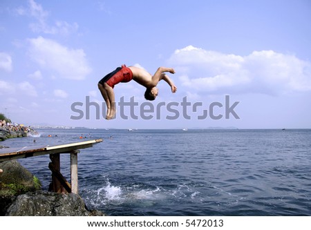 young man doing a back flip into sea, istanbul, turkey