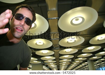 cool and hip man in airport with circular lamps