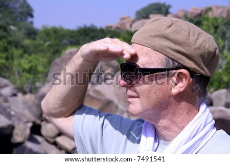 man looking into the distance with hand protecting from the sun light