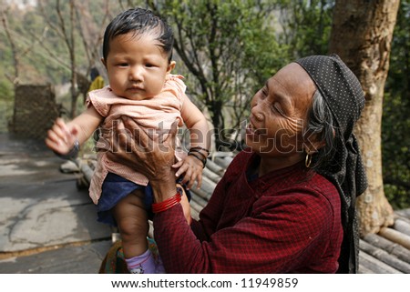 gurung grand mother with grandchild, annapurna, nepal