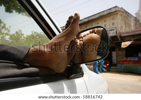 lazy taxi driver with feet up in car, Pushkar, India