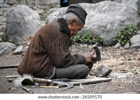 ANNAPURNA, NEPAL - MARCH 20: An unidentified man repairs his farming tools in a village on March 20, 2008 in Nepal.