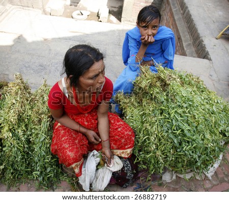 BHAKTAPUR, NEPAL- APRIL 13 : A local woman and her daughter sell local produce during Nepali New Year in Bhaktapur, Nepal on April 13, 2008.  Bhaktapur is located about 20 km east of Kathmandu.