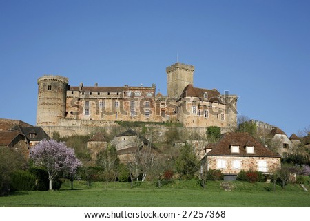 Castle and old village of Bretenoux in green fields, France